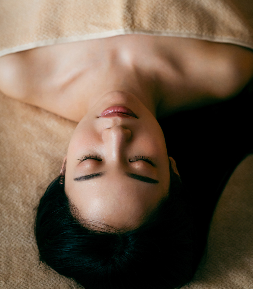 a close up of a person lying down and looking at the camera